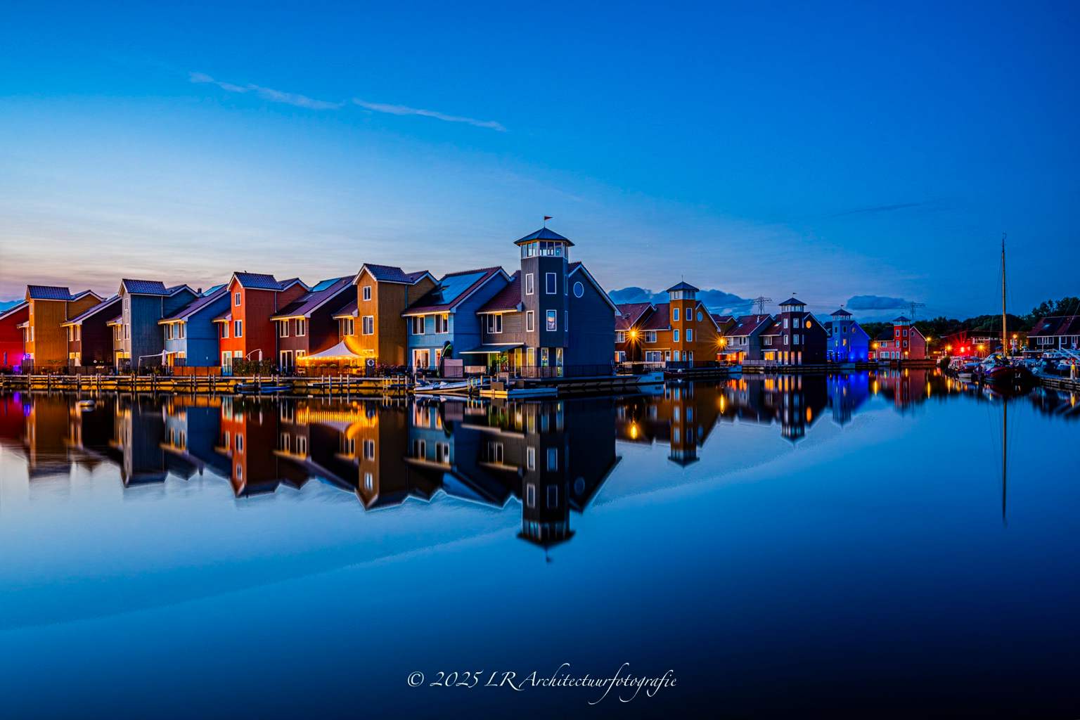 Architectuur tijdens het blauwe uur, verlicht en weerspiegeld in stil water.